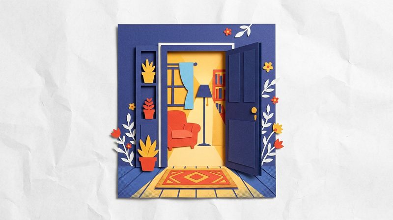 An open front door with warm light spilling onto a welcome mat and a cozy room waiting inside.